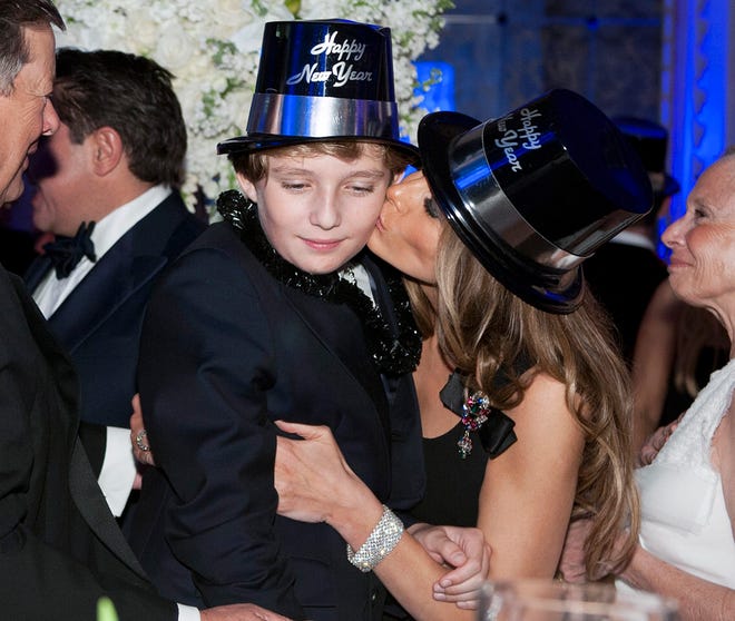 First Lady Melania Trump kisses her son Barron just after midnight at Mar-a-Lago Club on December 31, 2016 in Palm Beach.