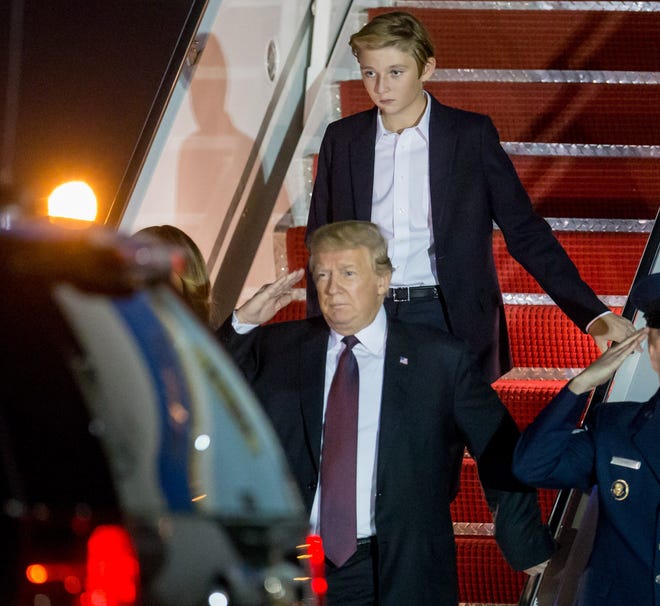 President Donald Trump and his son Barron arrive on Air Force One at Palm Beach International Airport on November 21, 2018.