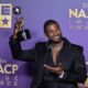 Usher poses with his entertainer of the year trophy during the 55th annual NAACP Image Awards on March 16, 2024.