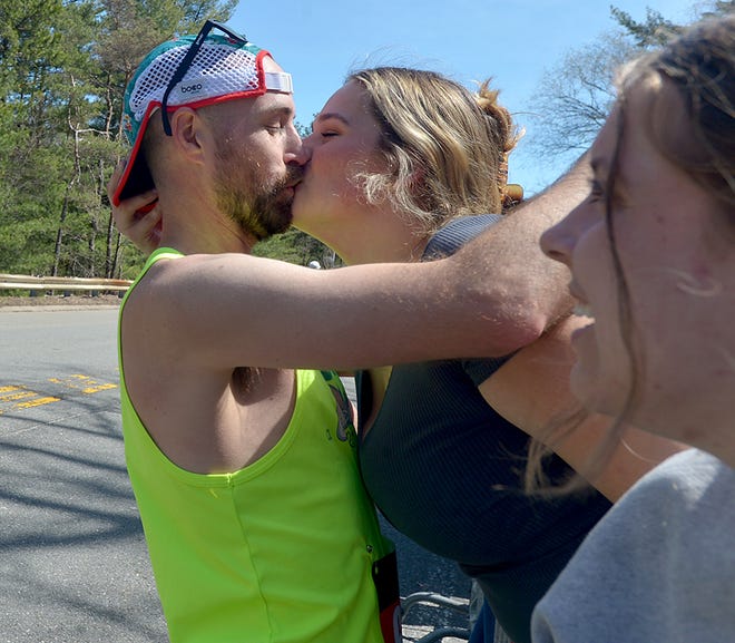 Chloe Theriault, a Wellesley College sophomore from Arizona, gets a kiss from runner Ryan Barrett, of Charleston, S.C., in the scream tunnel at Wellesley College during the 126th Boston Marathon, April 18, 2022.