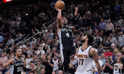 San Antonio Spurs guard Devonte' Graham (4) scores the winning shot over Denver Nuggets guard Jamal Murray (27) during the second half of an NBA basketball game in San Antonio, Friday, April 12, 2024. (AP Photo/Eric Gay)