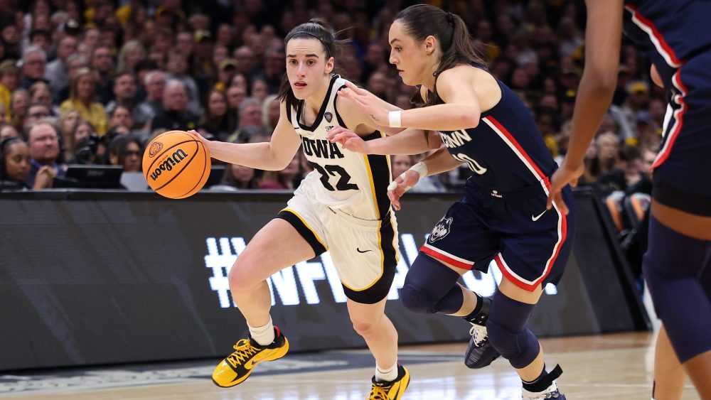 CLEVELAND, OHIO - APRIL 05: Caitlin Clark #22 of the Iowa Hawkeyes dribbles around Nika Muhl #10 of the UConn Huskies in the first half during the NCAA Women's Basketball Tournament Final Four semifinal game at Rocket Mortgage Fieldhouse on April 05, 2024 in Cleveland, Ohio. (Photo by Gregory Shamus/Getty Images)