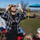 Madilyn Hafner, a Great Start Readiness Program preschool teacher from Mason Central Elementary, wears solar eclipse glasses to look up at the sun with her class during an activity in Erie on Thursday, March 7, 2024.