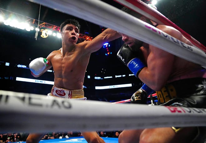 Jan. 27, 2024; Phoenix, Ariz; USA; Jaime Munguia throws a punch at John Ryder along the ropes in the fifth round during The Golden Boy Boxing Series at the Footprint Center.