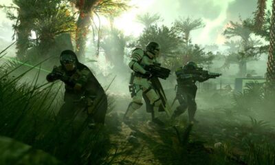 A three-person squad of Helldivers marches through the jungle with various weapons.