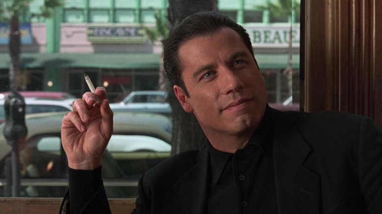 John Travolta as Chili Palmer with a cigarette in a nice restaurant in Get Shorty