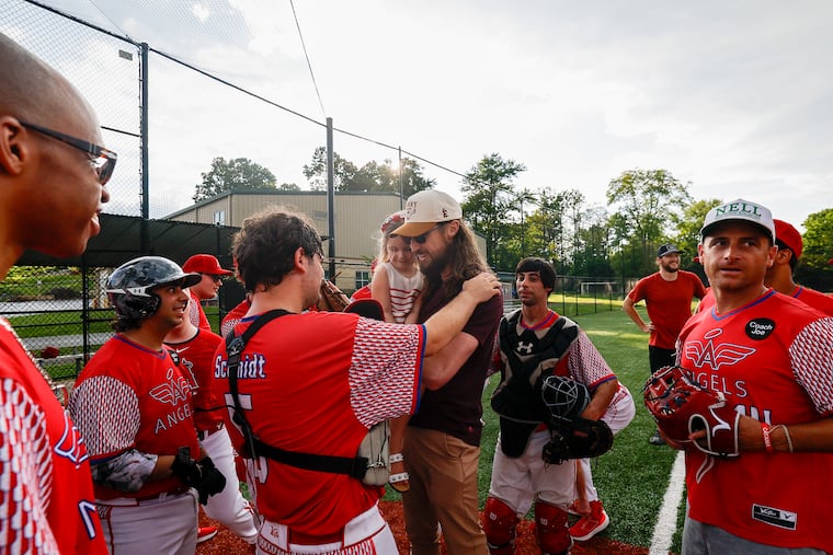 Phillies pitcher Matt Strahm, carrying his daughter, Wren, meets with members of the Angels before a ceremony unveiling the new scoreboard on July 20 at Gable Park in Newtown Township. The Angels are a baseball team for adults with functional needs.