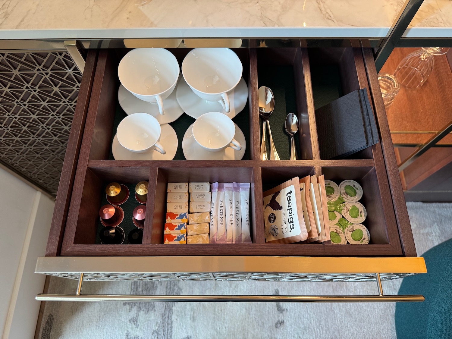 a drawer with tea cups and teaspoons