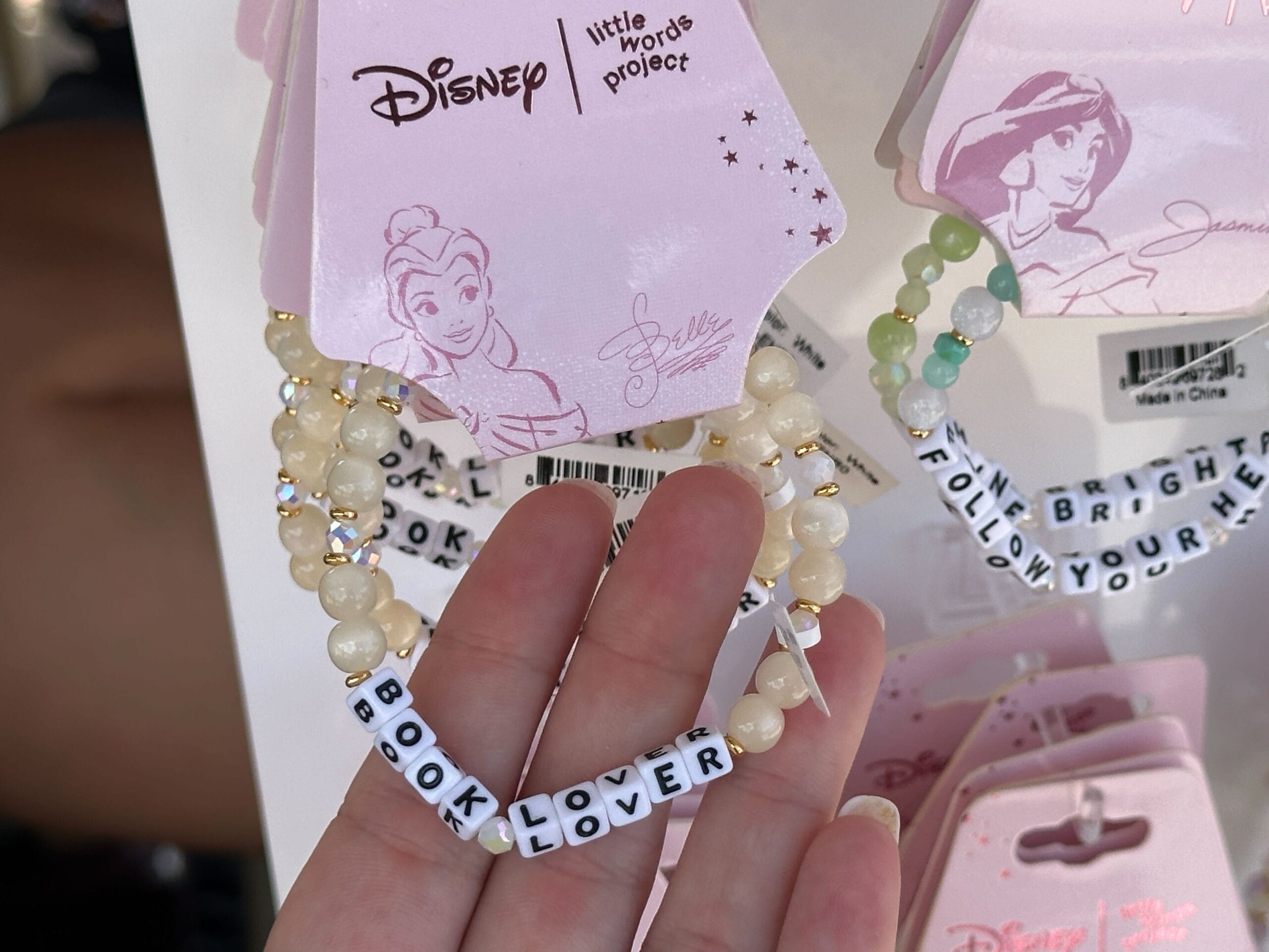 Hand holding a beaded bracelet that spells