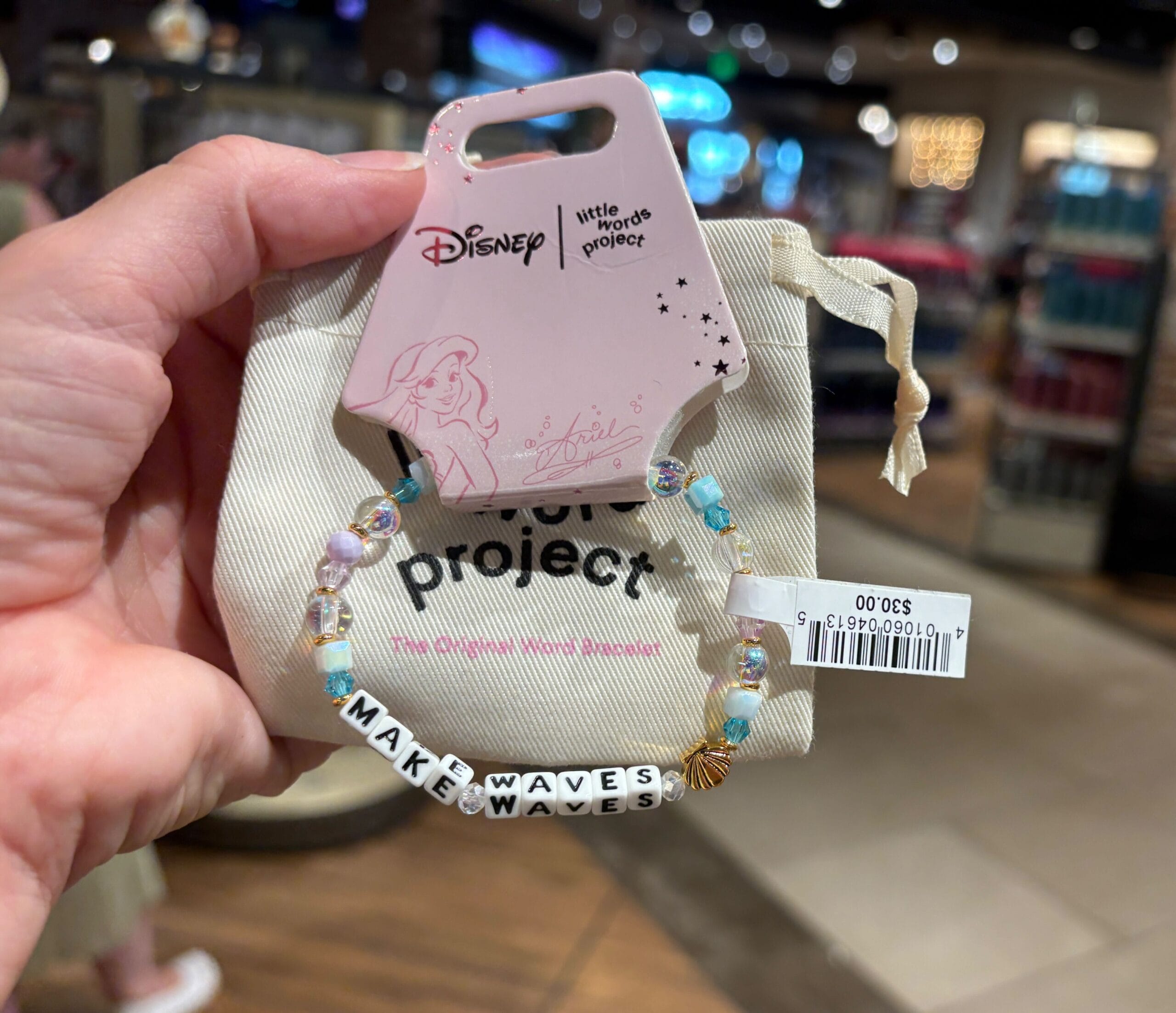 A hand holds a Disney