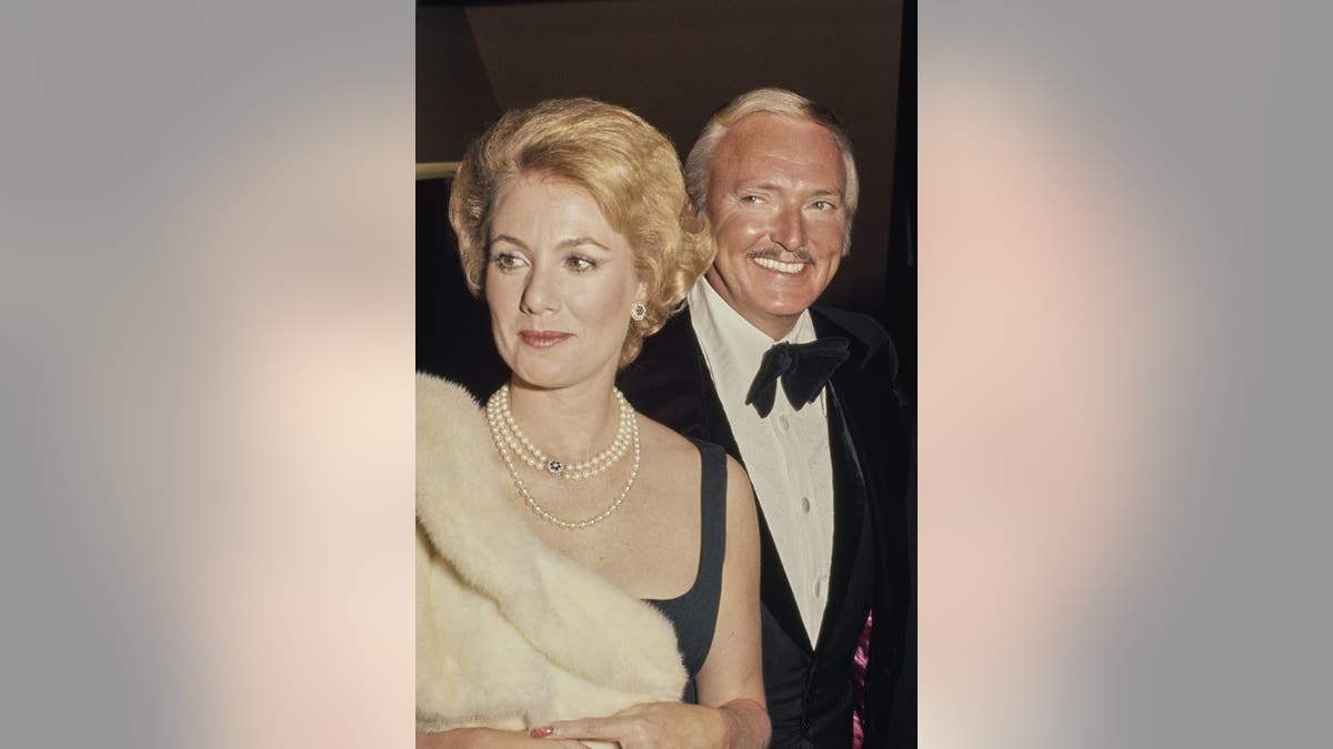 Shirley Jones in a black outfit with pearls and a white fur wrap, with husband Jack Cassidy in a tuxedo, attending an event in the United States, circa 1972.