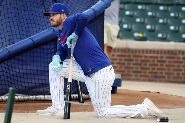 Cubs' Ian Happ watches teammates take batting practice at Wrigley...