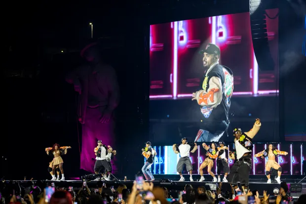Chris Brown moves and sings while flanked by his dancers...