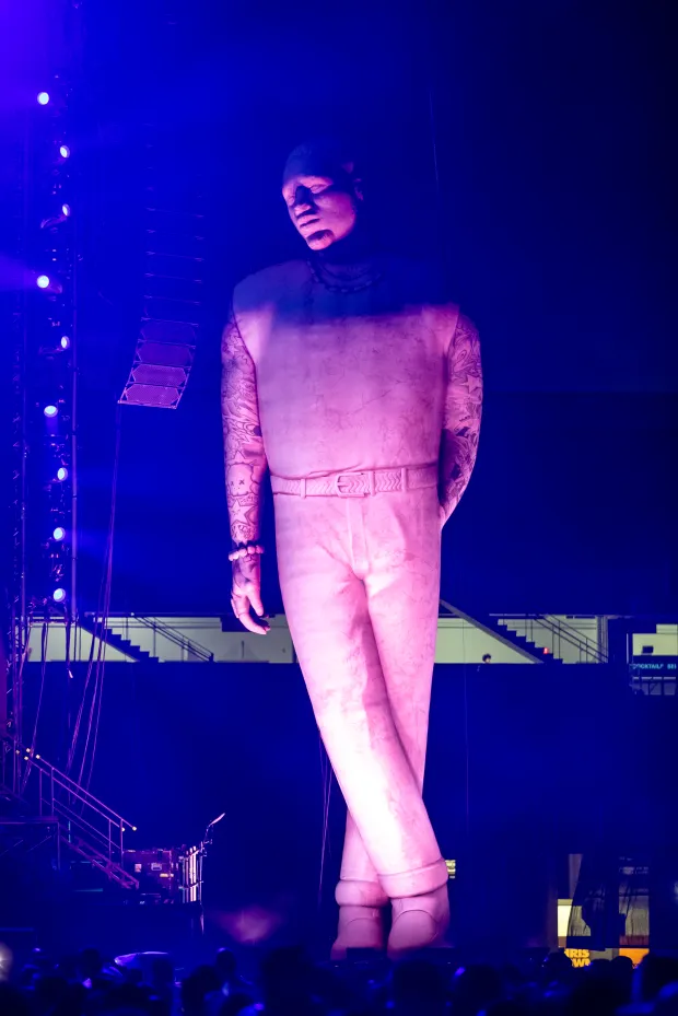 A giant inflatable statue of Chris Brown appears next to...