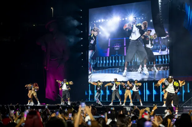 Chris Brown moves and sings while flanked by his dancers...