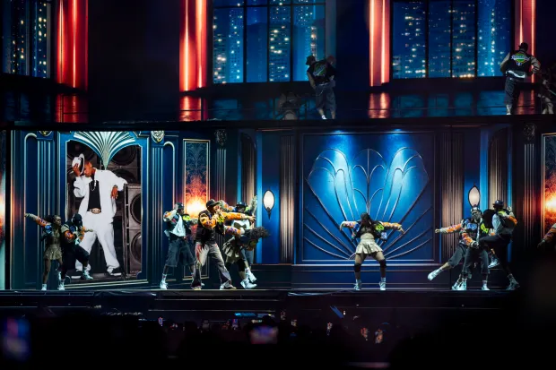 Chris Brown moves and sings while flanked by his dancers...