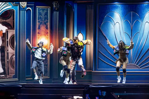 Chris Brown moves and sings while flanked by his dancers...