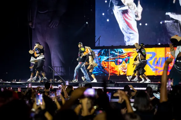 Chris Brown moves and sings while flanked by his dancers...