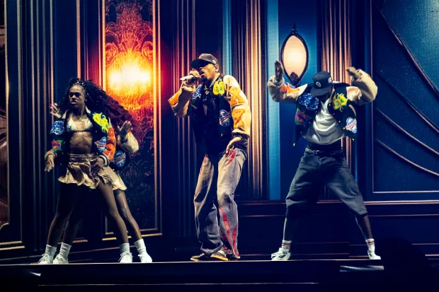 Chris Brown moves and sings while flanked by his dancers...